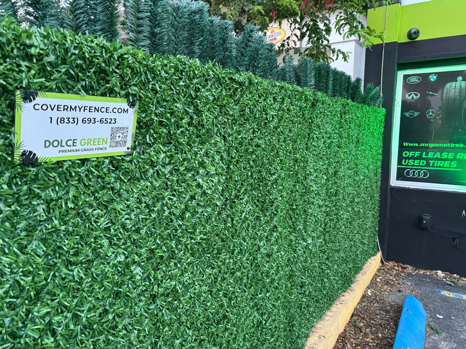Dolce Green grass fence installed at an auto shop, close-up