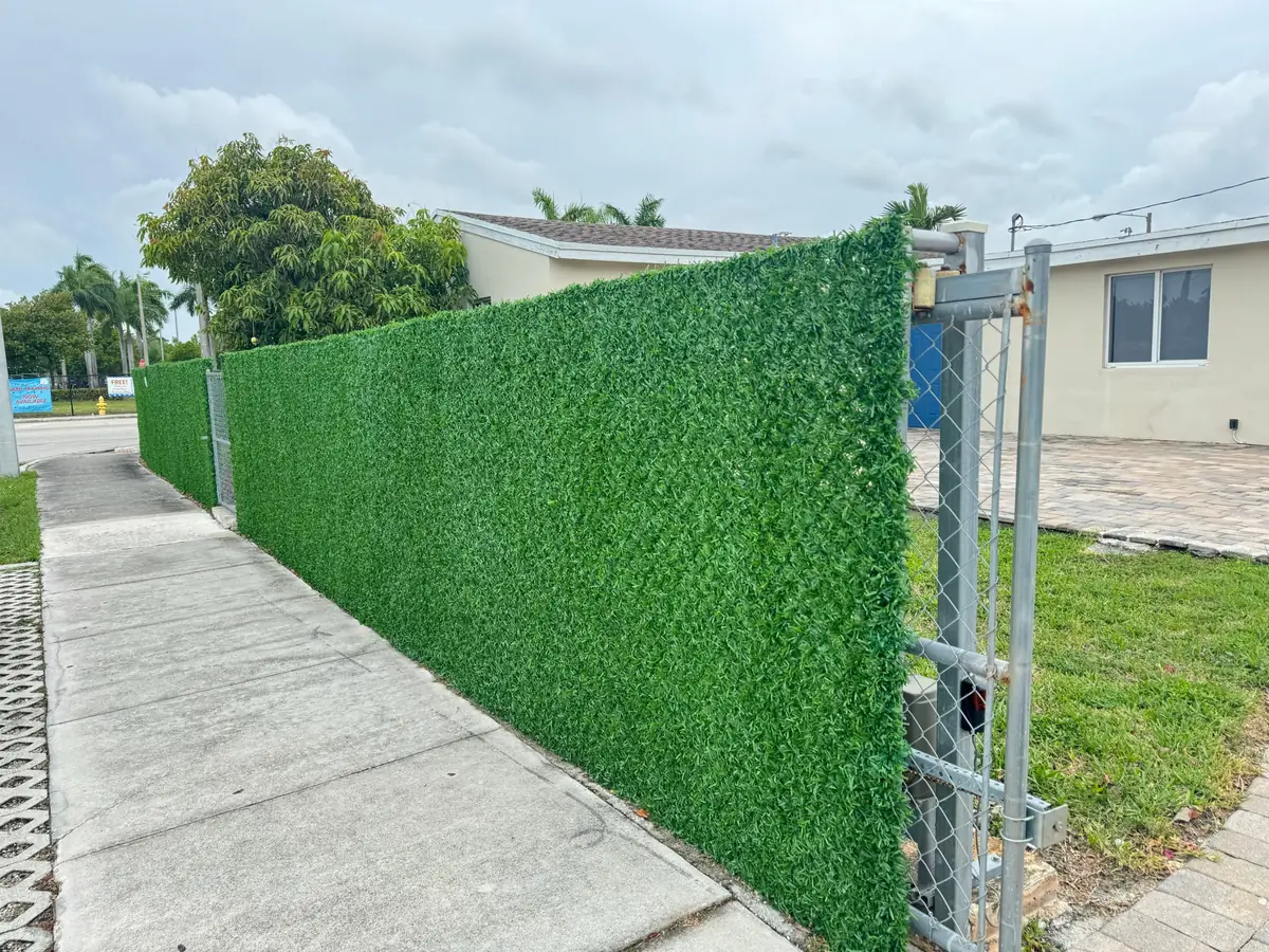 Front-yard chain-link gate covered with a Dolce Green grass fence roll
