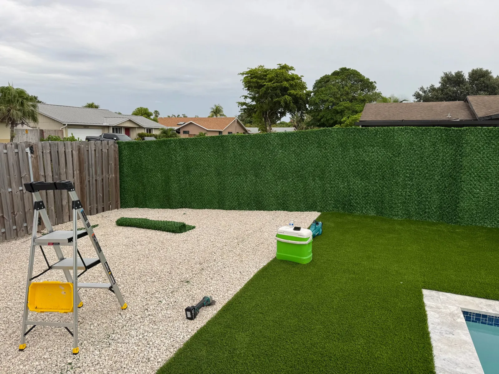 Backyard pool with turf and a Dolce Green grass fence privacy wall